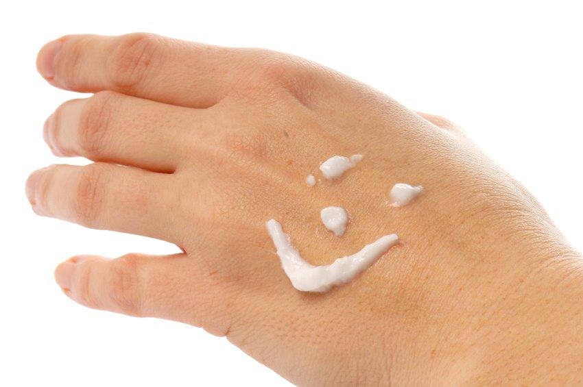 Hand mit Smiley aus Hautcreme