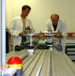 Two persons standing at the test bench