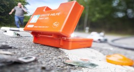 a first aid kit next to broken glass on a street