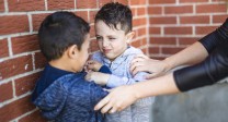 gestelltes Foto: Zwei Kinder werden von einer Erwachsenen getrennt