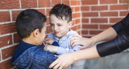 gestelltes Foto: Zwei Kinder werden von einer Erwachsenen getrennt